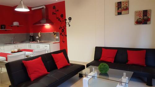 a living room with a black couch and red pillows at Apartamento Cotillo Playa in El Cotillo