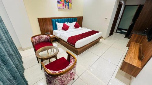 a bedroom with a bed and a chair in a room at Atalchhatra Luxury Boutique Hotel in Jaipur
