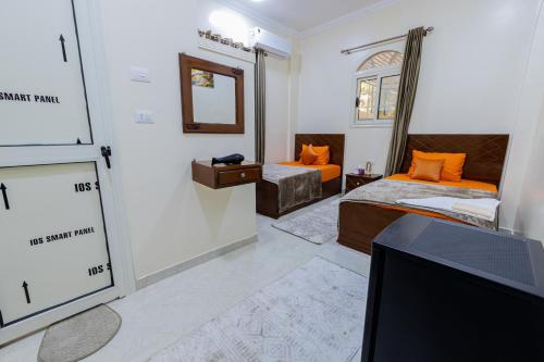 a room with two beds and a tv in it at Samara Guest House in Aswan