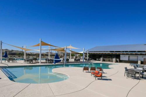 a large swimming pool with chairs and tables at Sosegado at The Parks in Queen Creek
