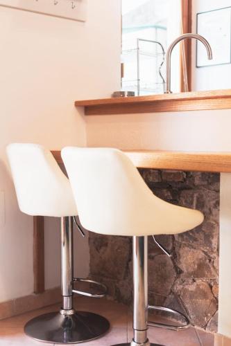two white chairs sitting in front of a counter at Mina Home in Gorizia