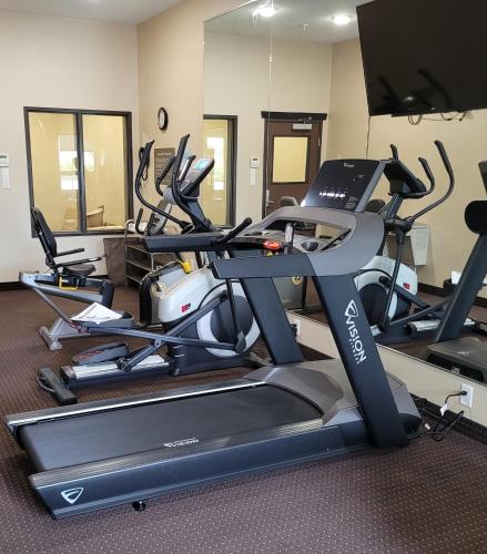 a gym with several tread machines and a treadmill at The Kanata Bonnyville in Bonnyville