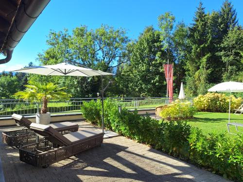 a patio with two benches and an umbrella at Sweet Cherry - Boutique & Guesthouse Tyrol in Innsbruck
