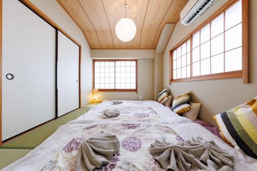 a large bed in a room with windows at Bliss KAMEARI in Tokyo