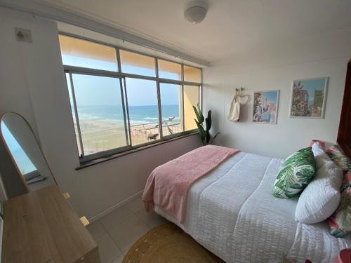 a bedroom with a bed with a view of the ocean at Chasing The Sun in Durban