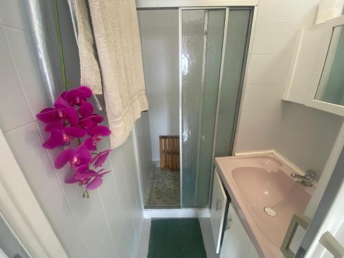 a bathroom with a sink and purple flowers on the wall at Chasing The Sun in Durban