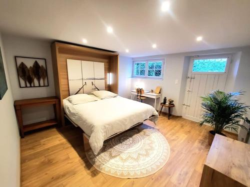 une chambre avec un grand lit et un tapis dans l'établissement Sur le chemin du Cens, à Orvault