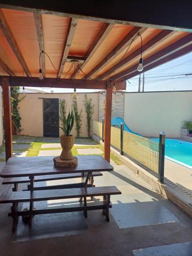 a picnic table on a patio next to a pool at Antônio Teixeira in Barão de Geraldo