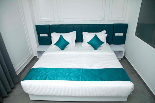 a bedroom with a large bed with blue and white pillows at Vimala Regency in Ādoni