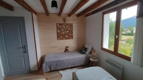 une petite chambre avec un lit et une fenêtre dans l'établissement le chalet Cerdan - classé 3 étoiles - 5 personnes-2 chambres- parking -garage-jardin-WIFI-rénové en 2023, à Bolquère-Pyrénées 2000