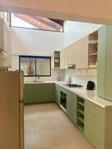 a large kitchen with green cabinets and a window at Entire Holiday Home in Shell