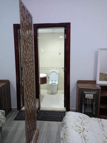 a bedroom with a bathroom with a toilet and a mirror at City Towers in Ajman 