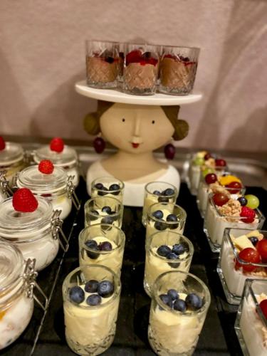 a doll with a tray of desserts in jars at Gästehaus Weiherhof in Alpbach