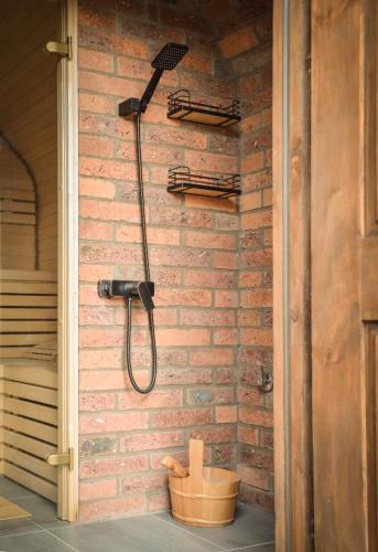 a shower on the side of a brick wall at Relaksatorium Sfera Beskidu in Sękowa