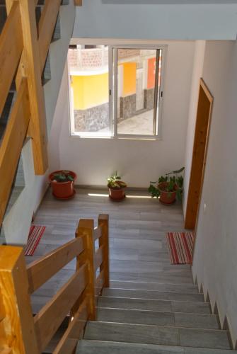 a room with stairs and a window and potted plants at Apart Laginha Tess & To in Mindelo