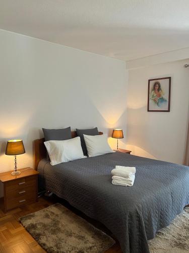 a bedroom with a large bed with two lamps at Discovery Apartment with patio Discovery 2 in Machico