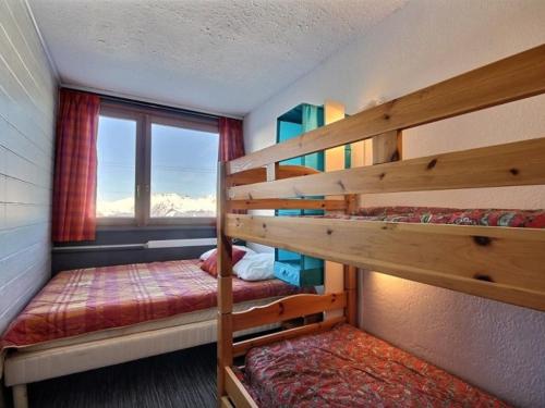 deux lits superposés dans une chambre avec fenêtre dans l'établissement Appartement rénové 3 pièces, au pied des pistes, orienté sud, proches commerces - FR-1-455-10, à La Plagne
