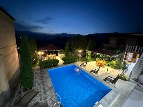 a swimming pool in a backyard at night at Colibri Hotel in Haghpat