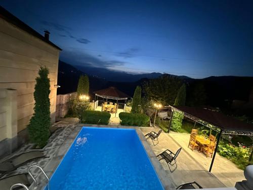 a house with a swimming pool at night at Colibri Hotel in Haghpat