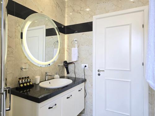 Eli's Seafront Apartment في سارنده: حمام مزود بحوض ومِرآة