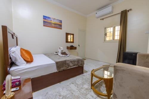 a bedroom with a bed and a table and a chair at Samara Guest House in Aswan