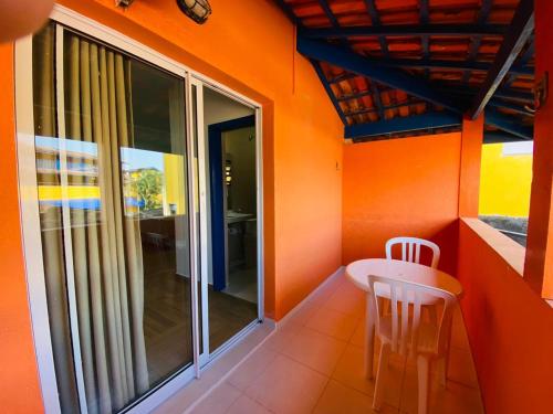an orange room with a table and two chairs at Kaliman Pousada in Ubatuba