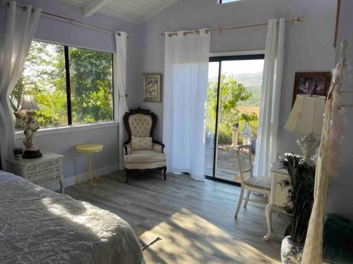 a bedroom with a bed and a window and a chair at Peacock Farm in Nipomo
