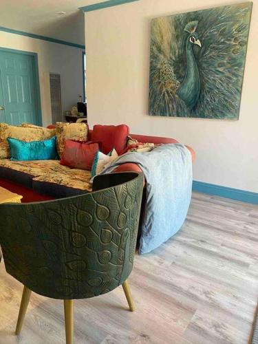 a living room with a couch and a peacock painting at Peacock Farm in Nipomo