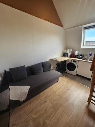 un salon avec un canapé bleu et une cuisine dans l'établissement Brun noisetier, à Tourcoing