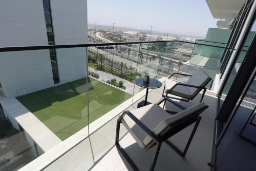 a balcony with two chairs and a table on a building at Address Residence Bahrain in Rayyā