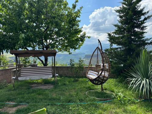 a chair in the grass next to a gazebo at Colibri Hotel in Haghpat