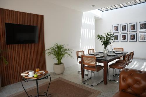 a dining room with a table and chairs and a television at Casa Elda in Mérida
