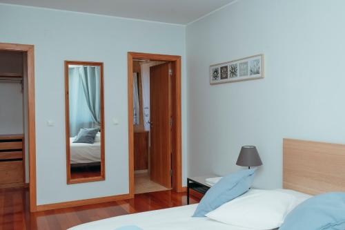 a bedroom with a bed and a mirror at Great Apartment Belavista in Leça da Palmeira