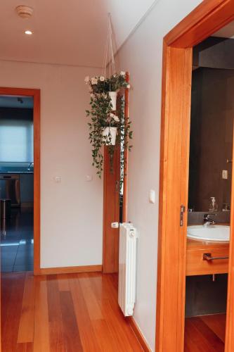 a bathroom with a sink and a door with a plant at Great Apartment Belavista in Leça da Palmeira