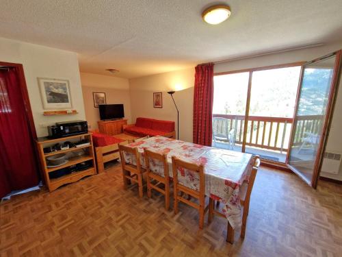 un salon avec une table, des chaises et un canapé dans l'établissement Spacieux appart 3 pièces + cabine, 10 pers, coeur de station, Valfréjus - FR-1-265-204, à Valfréjus