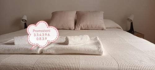 a white bed with towels and a sign on it at Il porto di Ale e Kat in Livorno