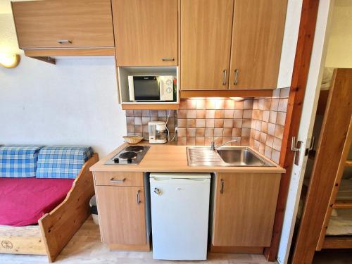une petite cuisine avec un évier et un micro-ondes dans l'établissement Charmant studio pour 2-3 pers avec balcon à Valfréjus - FR-1-265-236, à Valfréjus