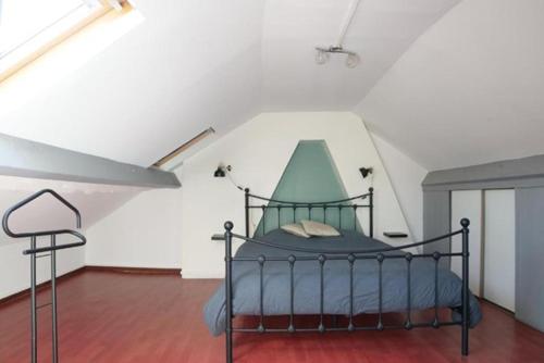 ein Schlafzimmer mit einem Bett in einem weißen Raum in der Unterkunft Grand Appartement proche CH Valenciennes in Valenciennes