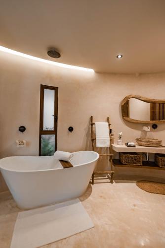 a large bathroom with a large tub and a sink at Taio Tulum in Tulum