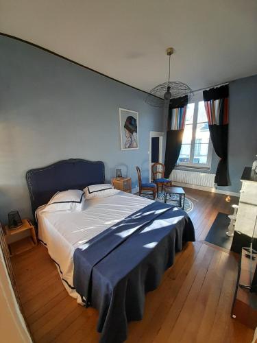 a bedroom with a large bed with a blue blanket at LA Coloc in Gournay-en-Bray