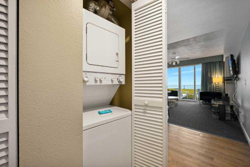 a white kitchen with a view of a living room at Luxury 6th Floor 1 BR Condo Direct Oceanfront Wyndham Ocean Walk Resort Daytona Beach | 610 in Daytona Beach