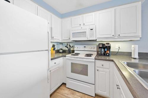 a kitchen with white cabinets and a white stove top oven at Penthouse Beach Villa Ocean Walk Resort Daytona in Daytona Beach