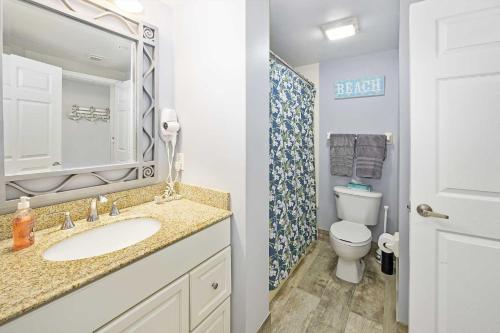a bathroom with a sink and a toilet and a mirror at Penthouse Beach Villa Ocean Walk Resort Daytona in Daytona Beach