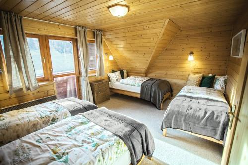 a bedroom with two beds in a log cabin at Chata Čučoriedka Litmanová in Litmanová