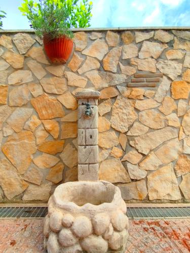 a stone fountain in front of a stone wall at Apartment 107 - Roma Fiumicino in Fiumicino
