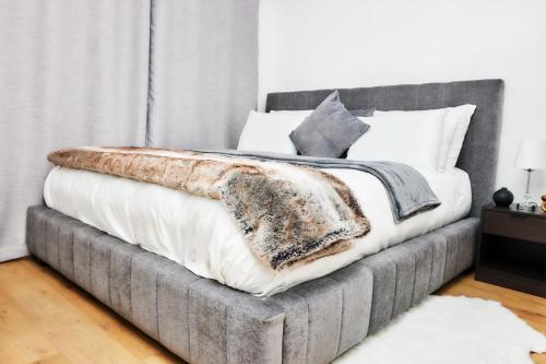 a bedroom with a bed with a gray bed frame at West Beach Luxury Apartment in Bloubergstrand