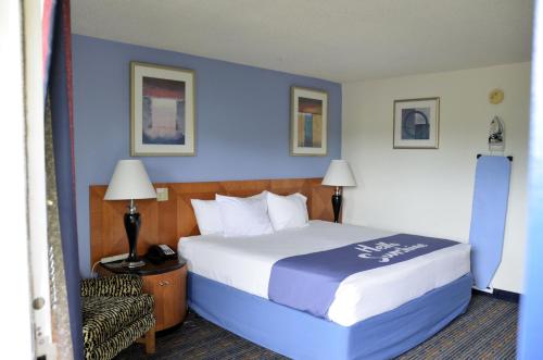 a bedroom with a large bed with a blue wall at Days Inn by Wyndham Luray Shenandoah in Luray