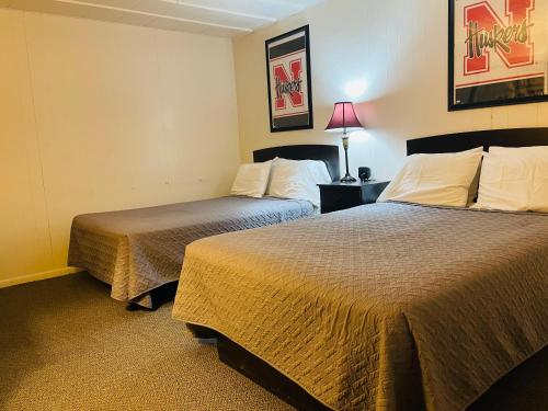 a hotel room with two beds and a lamp at Big Red Inn in Laurel