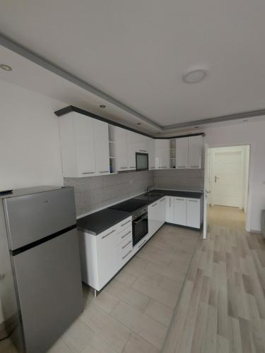 a large kitchen with white appliances and wooden floors at Apartment Flori in Ohrid