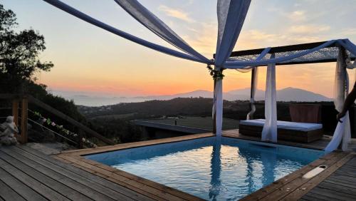 une piscine avec un coucher de soleil en arrière-plan dans l'établissement Villa spacieuse Albitreccia - 5 pièces 8 personnes - Villa 5 Pièces 8 personnes MAE-2711, à Zonza